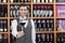 Bartender Offering Red Wine Glass Against Shelves