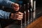 Bartender opens lot of glass bottles with lager on wooden bar counter