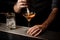 Bartender pouring an alcohol cocktail adding foam