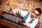 Bartender pouring alcoholic drink into small glasses on bar