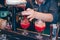 Bartender pouring cherry red cocktail using strainer Sweet spirit juicy drink on a bar counter . Barman background view. Copy past