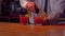 Bartender pouring cocktail into glass at bar counter in bar