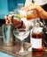 Bartender is pouring infusion into a mixing glass, toned