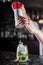 Bartender pouring powder on Sweet juicy Cocktail drink on a bar counter. Bartender view. Copy paste for design people