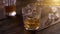 Bartender pouring whisky from bottle in to glass on rustic wooden table