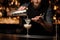 Bartender pours cocktail adding sour mix in glass