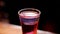 Bartender pours a cocktail in a glass at night