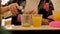 The bartender pours juice from a metal stack into plastic cups. Close-up of the bartender`s hands. Bar counter.