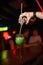 The bartender pours a ready, green cocktail from a shaker into a glass