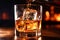 The bartender pours whiskey into a glass with ice on the bar counter. close-up. Blurred background. Elite alcoholic drink