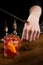 Bartender puts a drop of Negroni alcoholic cocktail on his hand and tastes it. Barman prepares classical Negroni