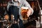 Bartender serves light beer to client at bar interior of pub