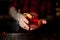 Bartender serving glass of a delicious Boulevardier cocktail with orange zest on the bar counter