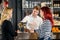 Bartender Serving Wine To Customers In Bar