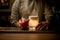 Bartender sprinkles on glass of drink with foam and decorative leaf and pumpkin on bar.