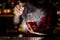 Bartender sprinkling bitter into the glass with red sweet cocktail