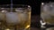 Bartender stirring ice cubes in a  glass with  bar spoon on the wooden bar counter