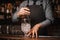 Bartender stirring ice cubes with help of spoon