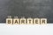 barter word, text written on wooden cubes on a black background with coins on cubes