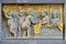 Bas relief in stone and gold of cherubs in a textile workshop