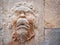 Bas-relief on a wall of the face of an antique Greek god