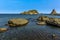 Basalt rocks above and below the sparkling blue sea at Aci Trezza, Sicily