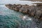 Basalt rocks in the ocean. Volcanic texture of vertical columns at the coast