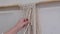 The base knots of macrame, the view from behind the shoulder close-up of the women hands, she ties knots. ECO friendly