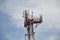 Base transceiver station (BTS) with antenna isolated on blue sky background. Telecommunications radio tower cells