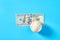 Baseball ball and banknote of 100 dollars on blue background