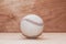 Baseball ball on wooden background. Handmade, Sports. Game inventory. Manufacture of wood and leather.