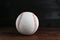 Baseball ball on wooden table, closeup. Sportive equipment