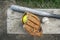 Baseball bat glove and balls on a wood bench