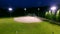 Baseball game on a field at a park in the evening