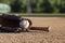 Baseball in a mitt with a brown bat low angle selective focus view on a baseball field