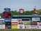 Baseball player stands in the outfield with ads on wall including LL Bean, Ford, Subway, Dunkin Donuts