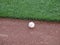 Baseball rest on edge of warning track beyond the outfield grass