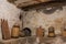 Basement old house wooden beams, antique household, carboy demijohn, stewpot, plank, Wicker basket, pulley with chain