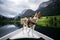 Basenji dog sits on boat at alpine lake