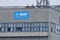BASF blue banner on exterior of concrete factory building, cloudy skies