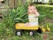 Bashful, coy baby boy in yellow wagon
