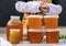 Bashkir bee honey is unpacked in various glass and plastic containers, and is ready for sale at an agricultural fair.