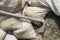 Basic Construction or repair - Close-up of bags of cement mix piled haphazardly and tool for spreading it leaning against them on