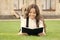 Basic education. Adorable little girl learn reading. Schoolgirl school uniform laying on lawn with favorite book