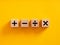 Basic mathematical operations symbols. Plus, minus, multiply and divide symbols on wooden cubes on yellow background