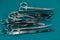 Basic surgical instrument scalpel forceps tweezers scissors spread on surgical green drape