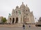 Basilica of the Sacred Heart of Paris with tourists in front on an overcast day