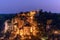 Basilica Saint-Sauveur below and Rocamadour Castle above solid rock illuminated after sunset. Lot, Occitania