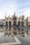 Basilica San Marco reflected in Acqua Alta high tide in Piazza San Marco, Venice, Italy