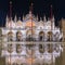 Basilica in San Marco square in Venice with reflection at night during the high tide